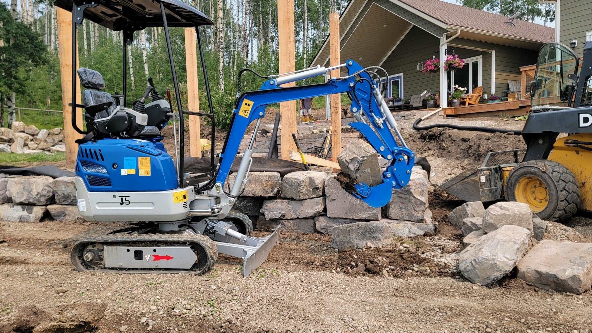1.2 ton mini excavator hiring for residential landscaping in Calgary Alberta efficient compact machinery moving heavy rocks for construction use

