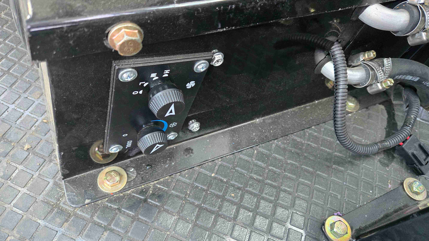 interior control panel of 1.5 ton compact wheel loader showing heater and ventilation adjustment knobs inside the cabin in Canada

