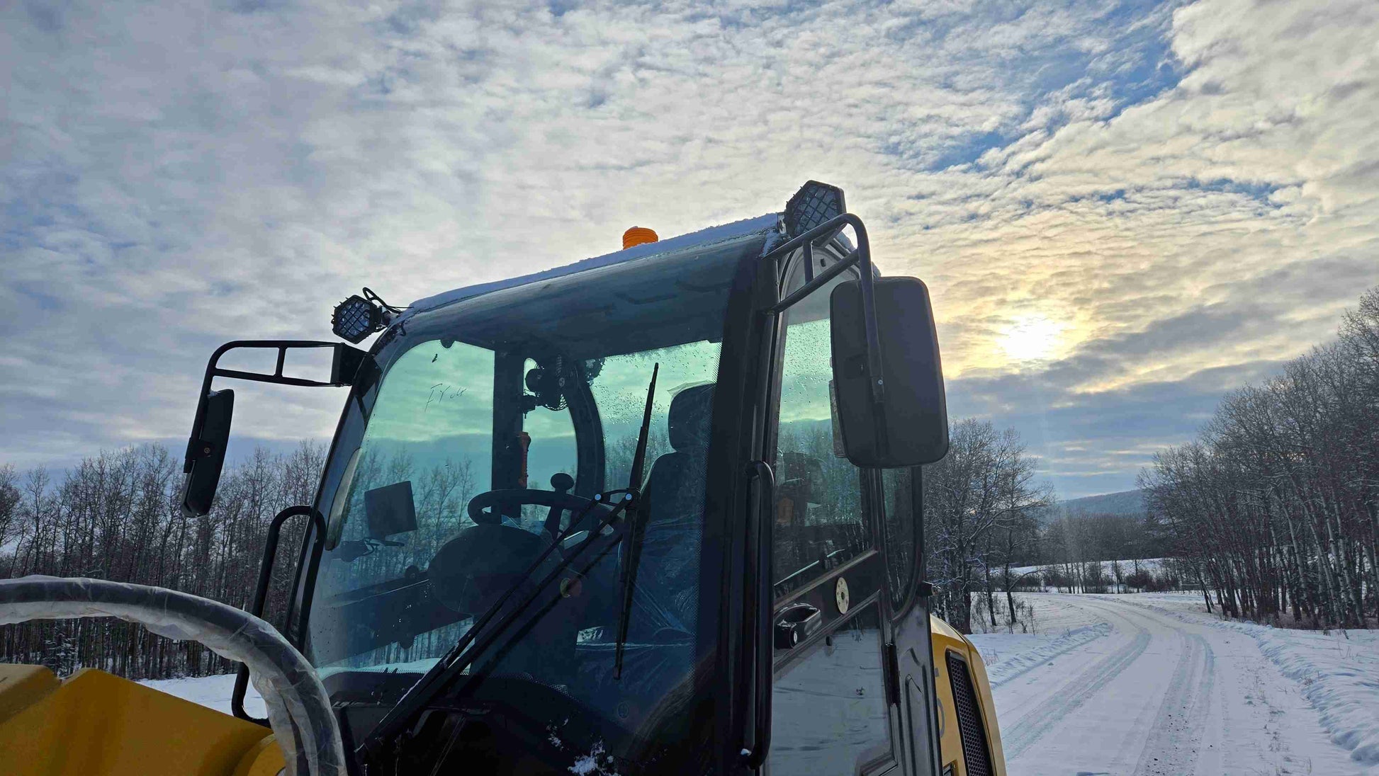 front cabin view of 1.5 ton compact wheel loader in Canada showing windshield mirrors and safety lights for construction and farm work