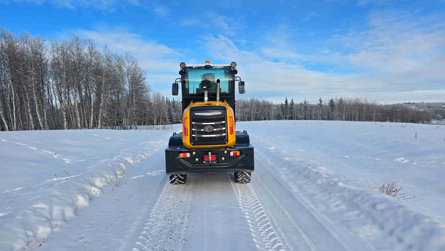 front view of 1.5 ton compact wheel loader on snowy road in Canada ideal for construction farming and snow removal applications

