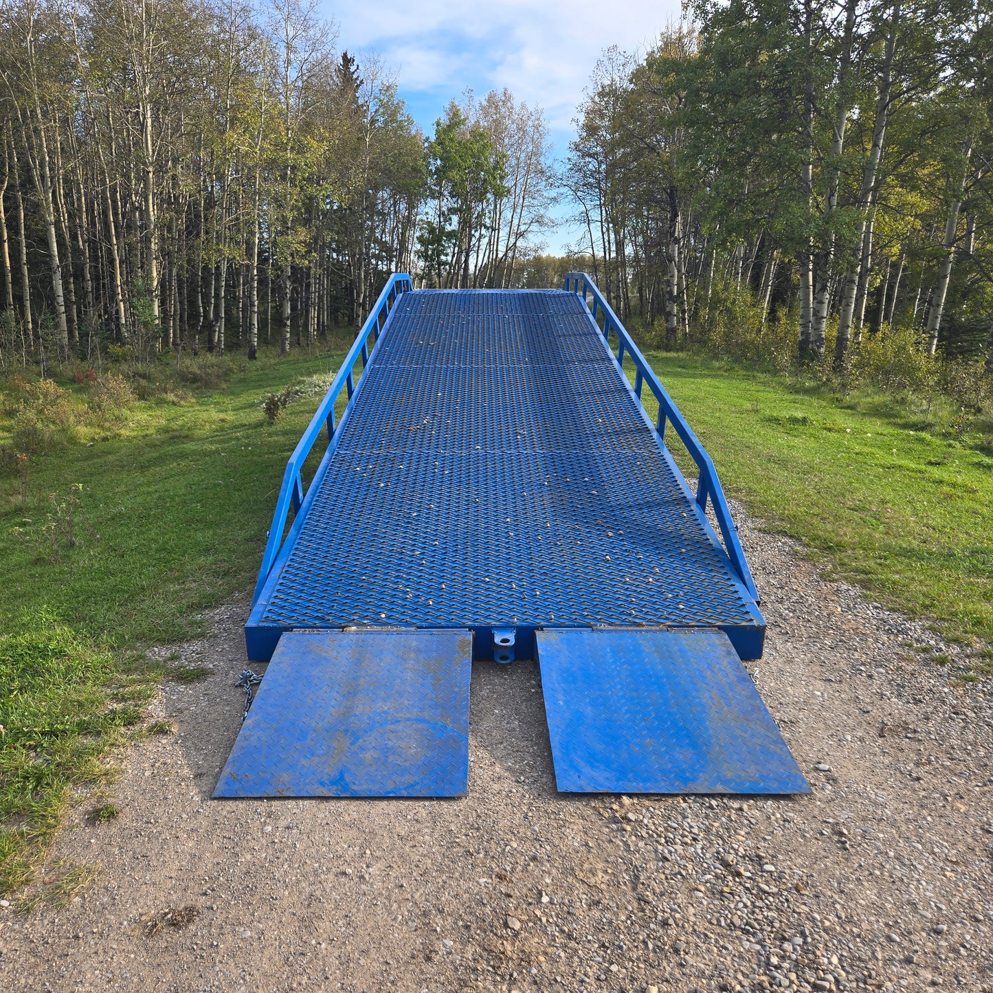 Twelve ton mobile loading ramp front view showing blue steel platform with safety rails for forklift and truck container loading in Canada

