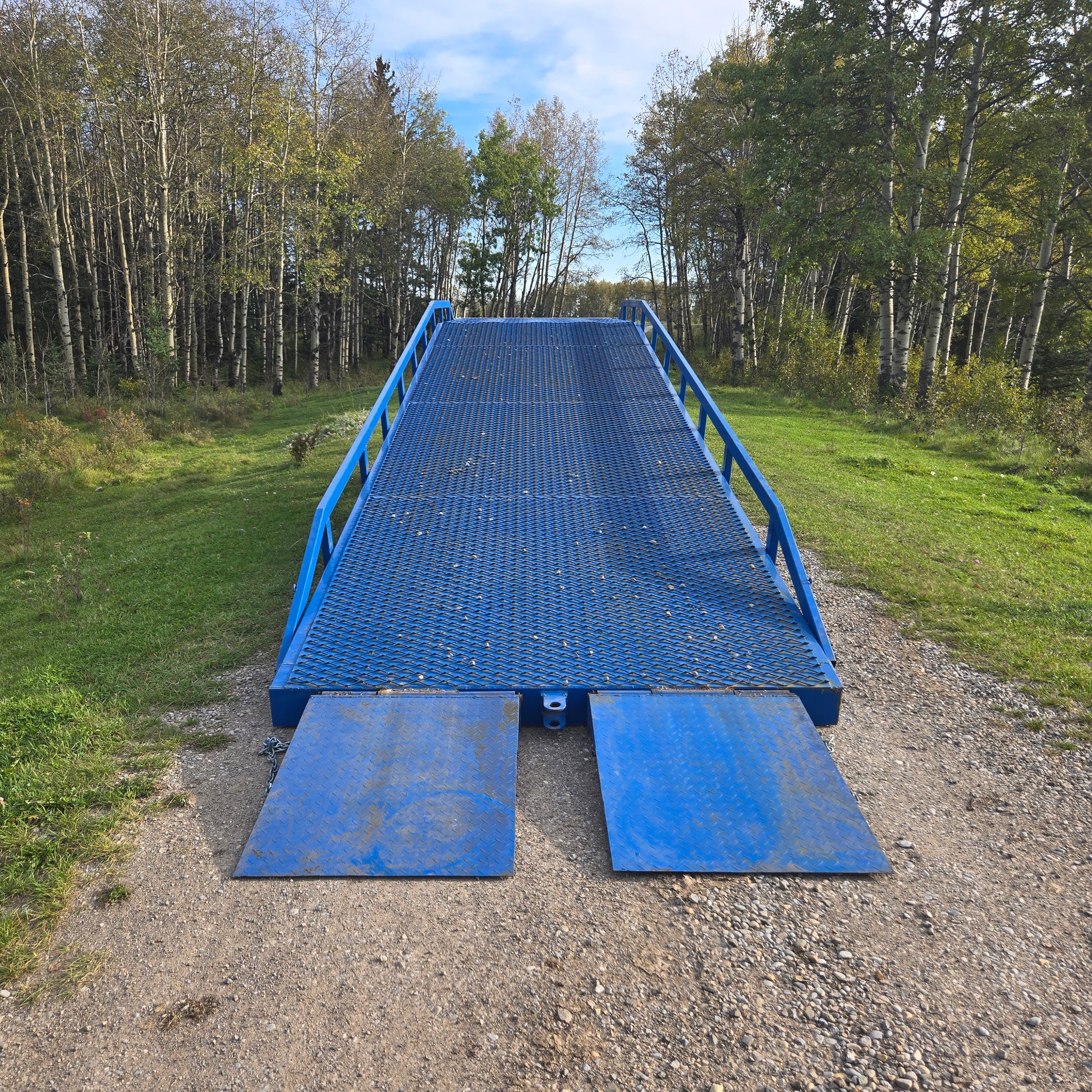 Twelve ton mobile loading ramp front view showing blue steel platform with safety rails for forklift and truck container loading in Canada

