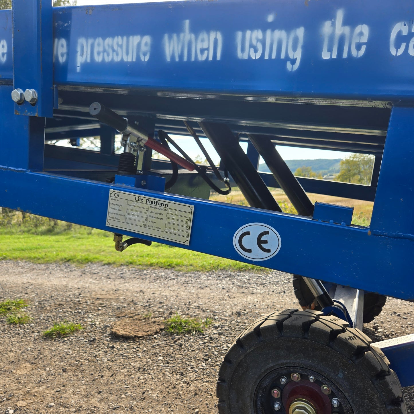 Close up view showing blue steel hydraulic frame and heavy duty wheel system of twelve ton mobile loading ramp for forklift and truck in Canada

