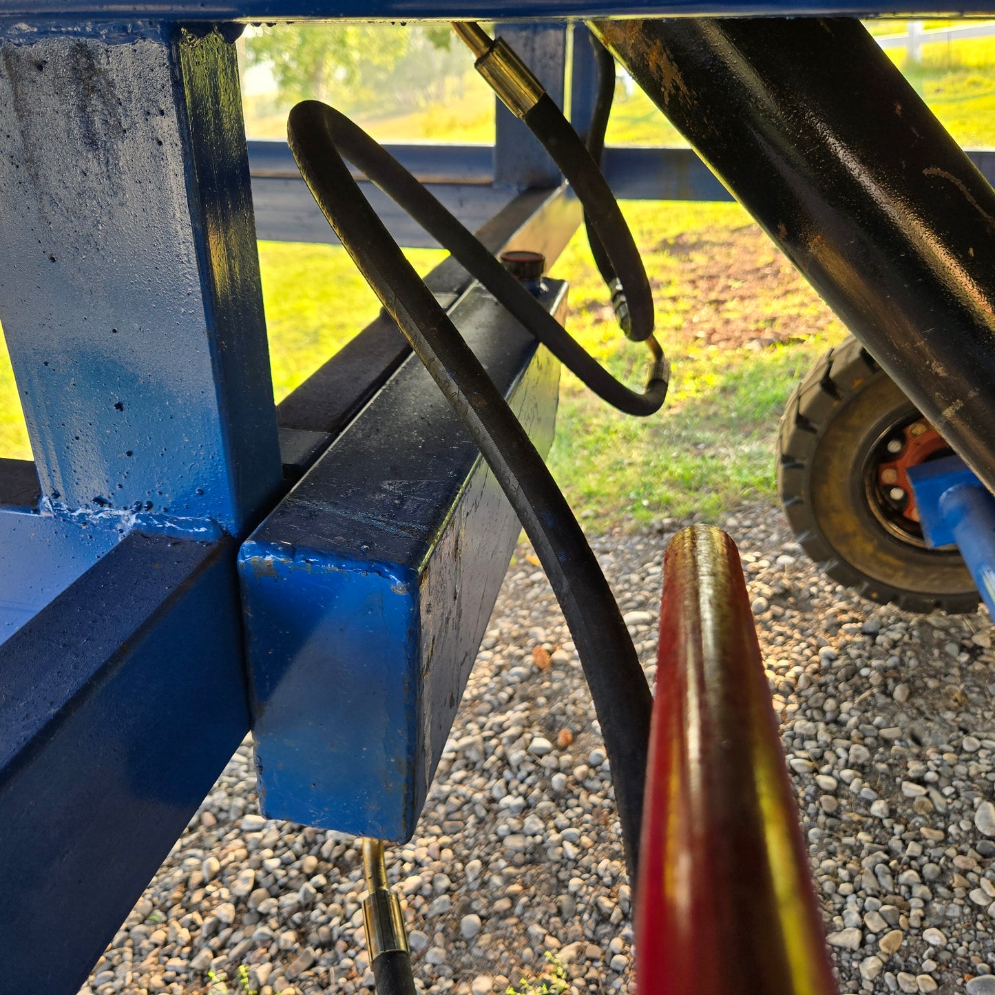 Close up view showing hydraulic hose connection system under blue steel mobile loading ramp used for forklift and truck loading in Canada

