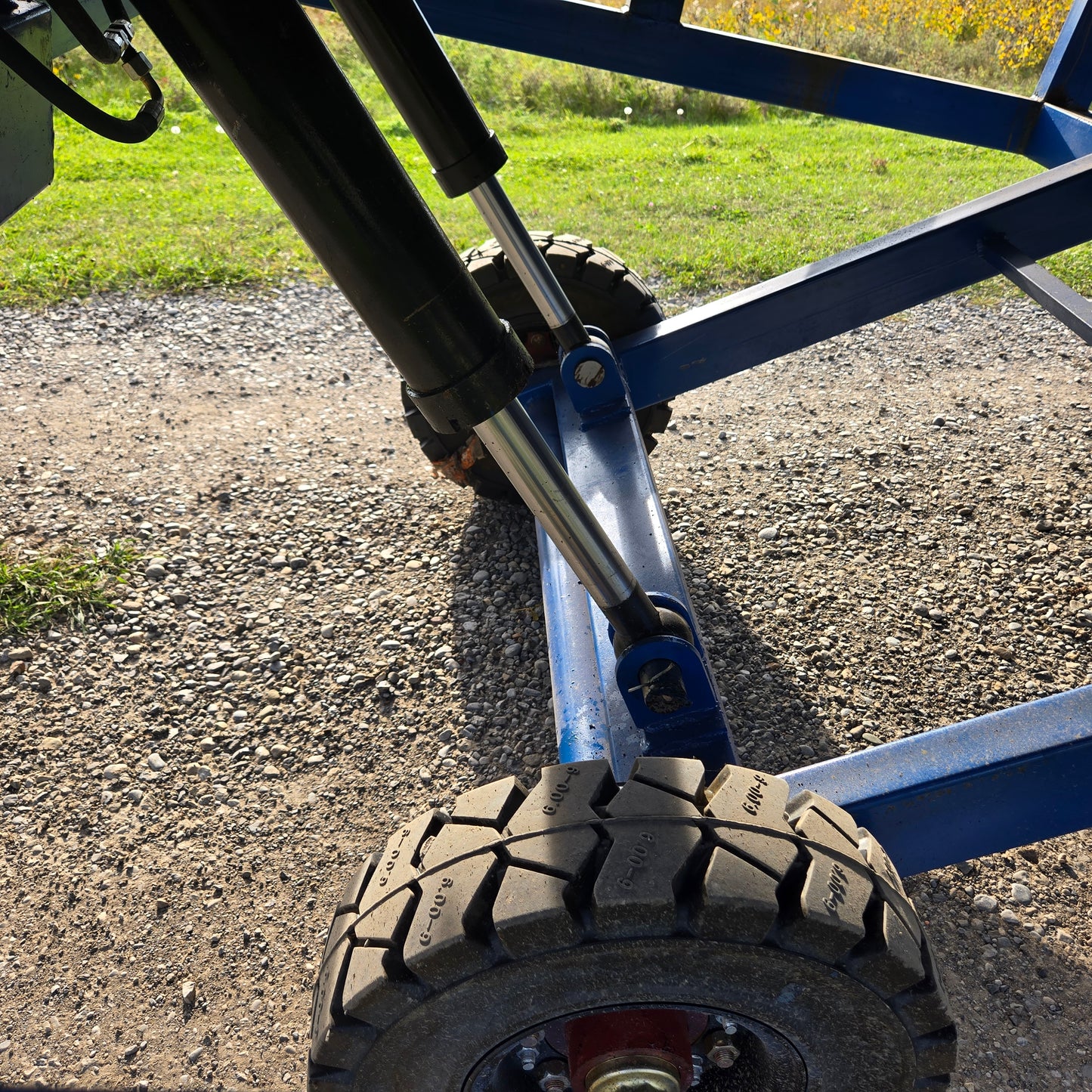 Close up hydraulic wheel system of twelve ton mobile loading ramp showing strong tire and lift mechanism for forklift and truck loading in Canada

