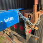 Close up view showing safety chain connection between blue steel mobile loading ramp and truck container for forklift loading in Canada