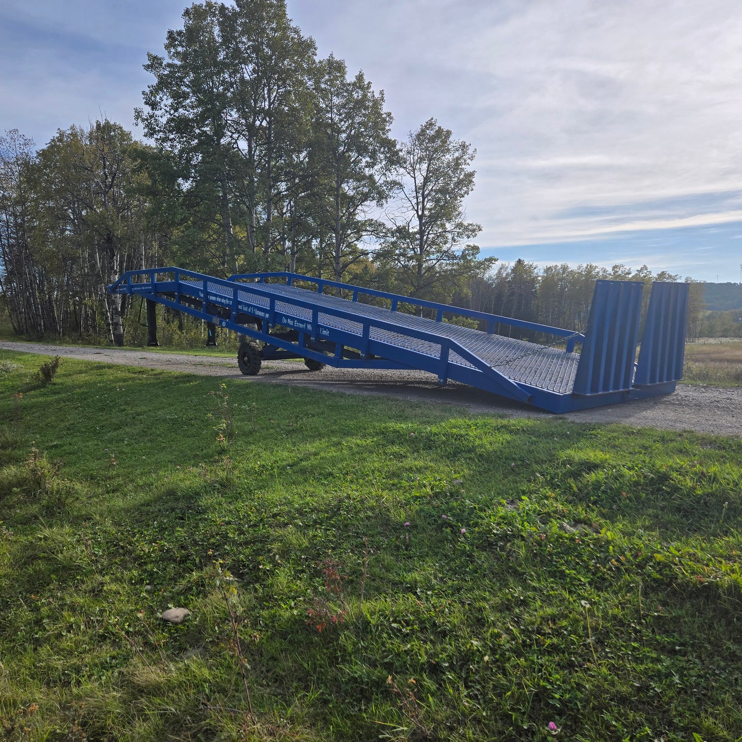Twelve ton mobile loading ramp outdoor side view showing blue heavy duty steel frame used for forklift and truck container loading in Canada

