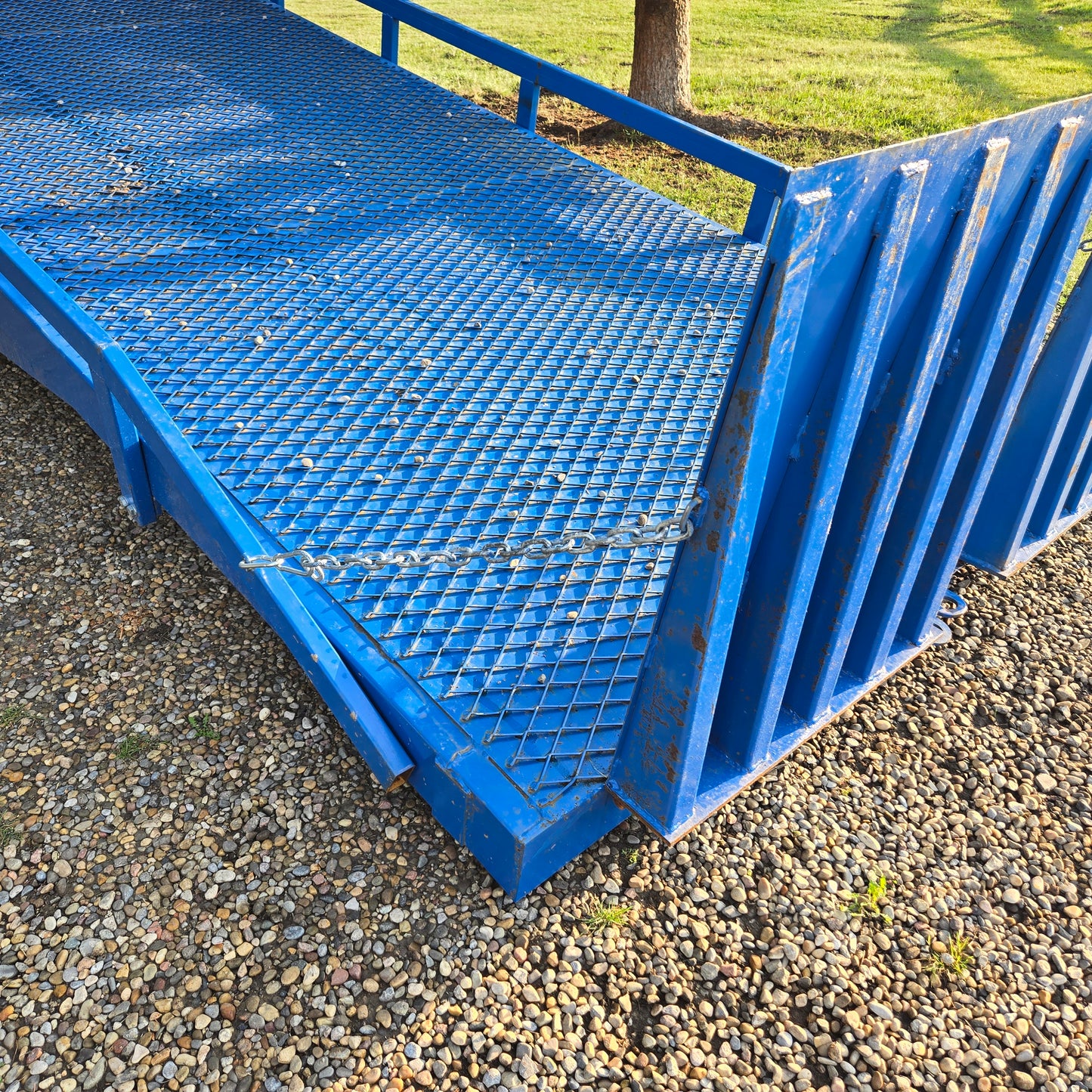 Twelve ton blue steel mobile loading ramp side angle showing grip platform and safety rails used for forklift and truck container loading in Canada


