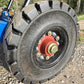 Close up view of heavy duty solid rubber wheel with red hub and steel bolts used on twelve ton mobile loading ramp for truck and forklift in Canada

