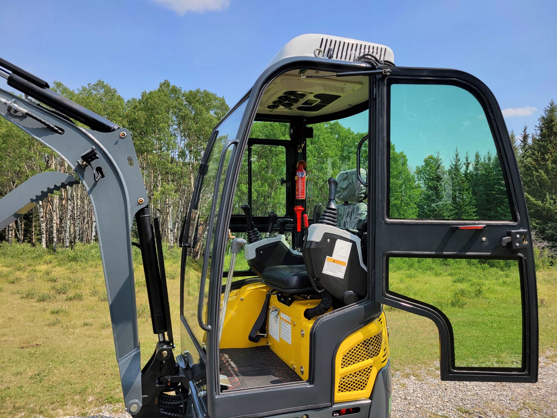 2 ton mini excavator full cab interior showing operator seat and controls with open door in Calgary Alberta available for rent for compact construction work

