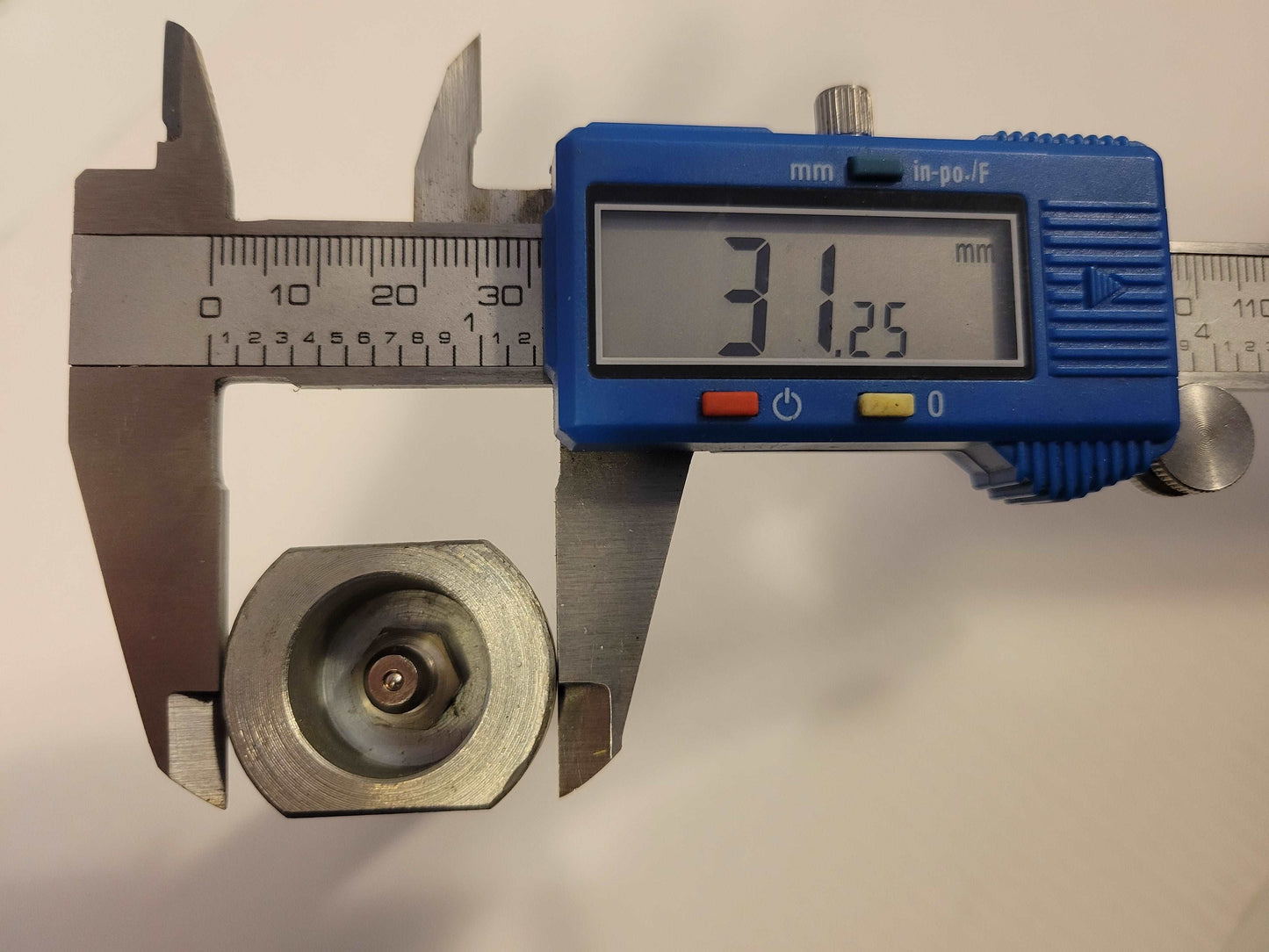 digital caliper measuring metal nut of 25 millimeter bucket pin for Agrotk and FF Industrial mini excavator replacement parts in Canada showing precision size