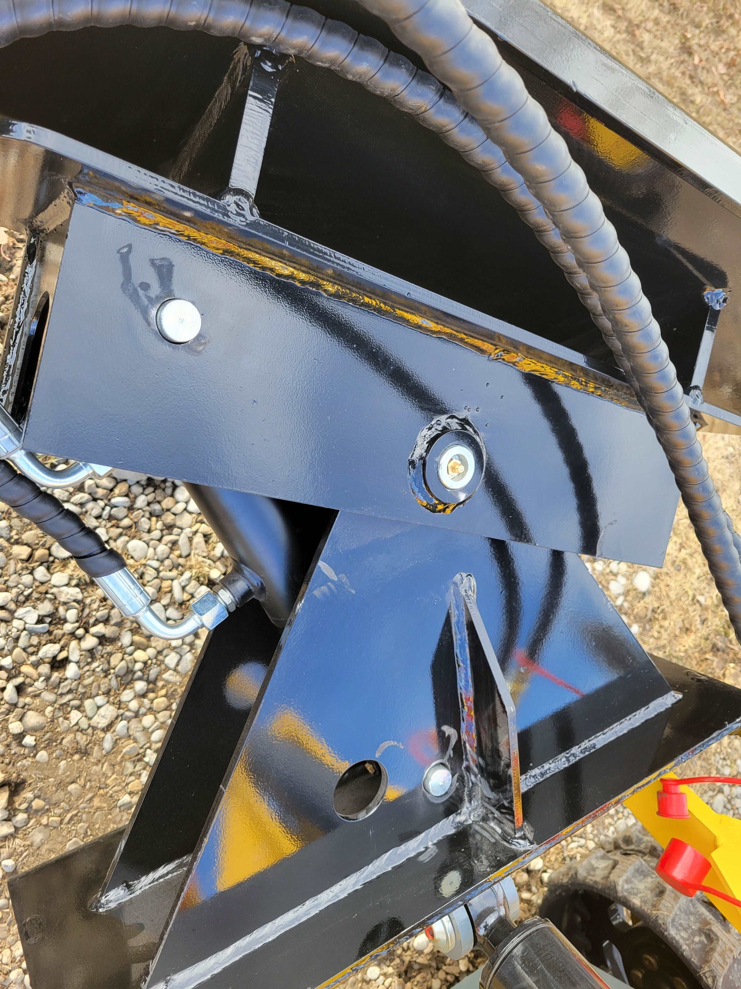 Close-up of hydraulic mounting bracket and fittings on JoyT5 JT5SSTM3 tracked mini skid steer 23 HP compact loader for construction and landscaping in Canada