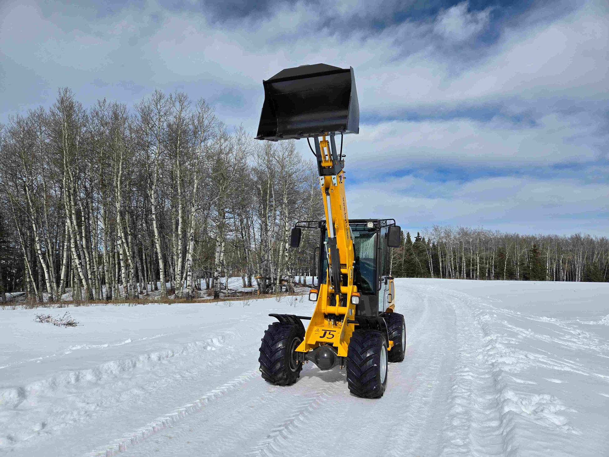 JT5WL1000 compact wheel loader 1 ton 2200 lbs front view bucket up working in snow road