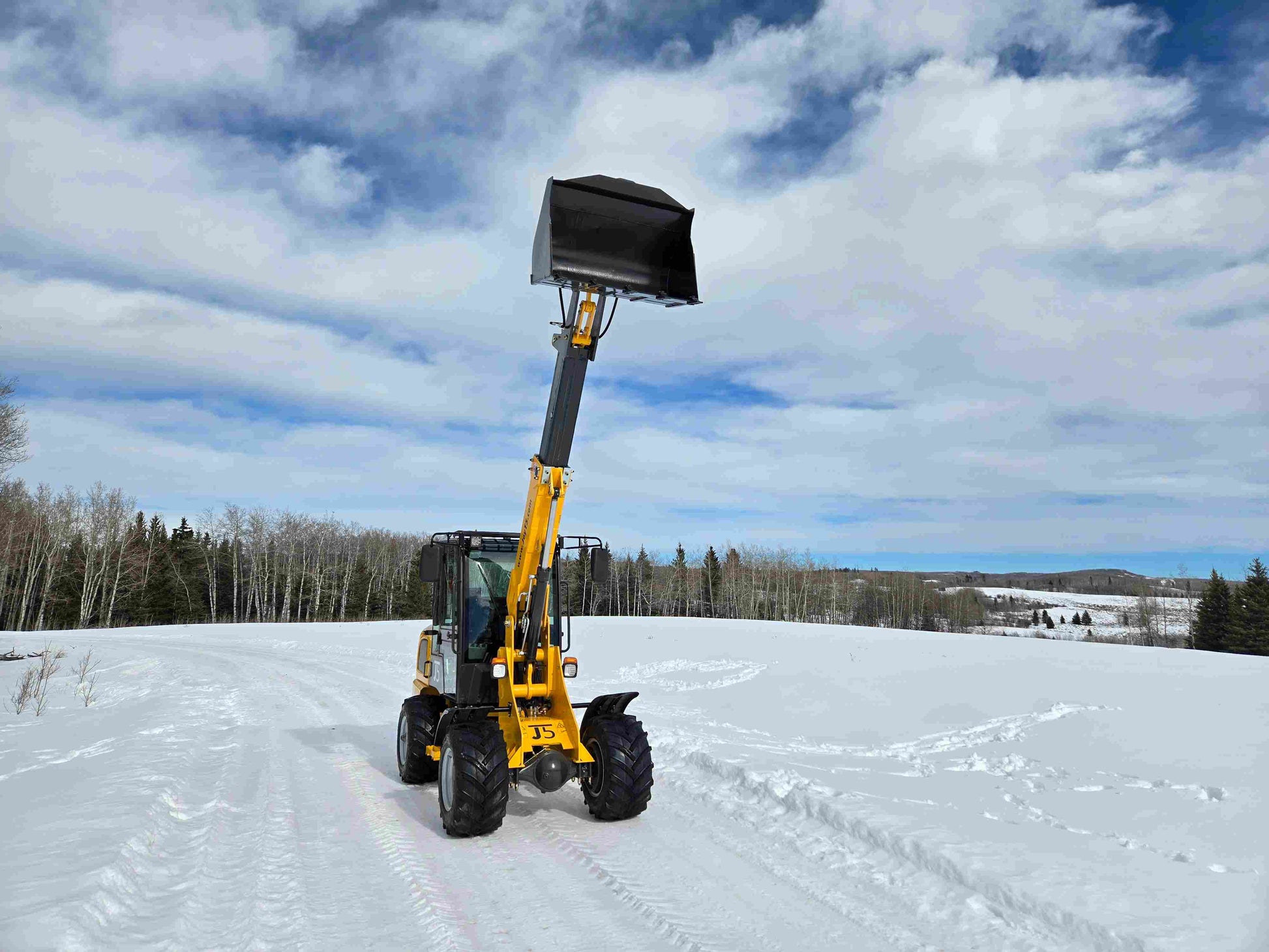 JT5WL1000 compact wheel loader 1 ton 2200 lbs front view with telescopic boom extended and raised bucket working in snowy field