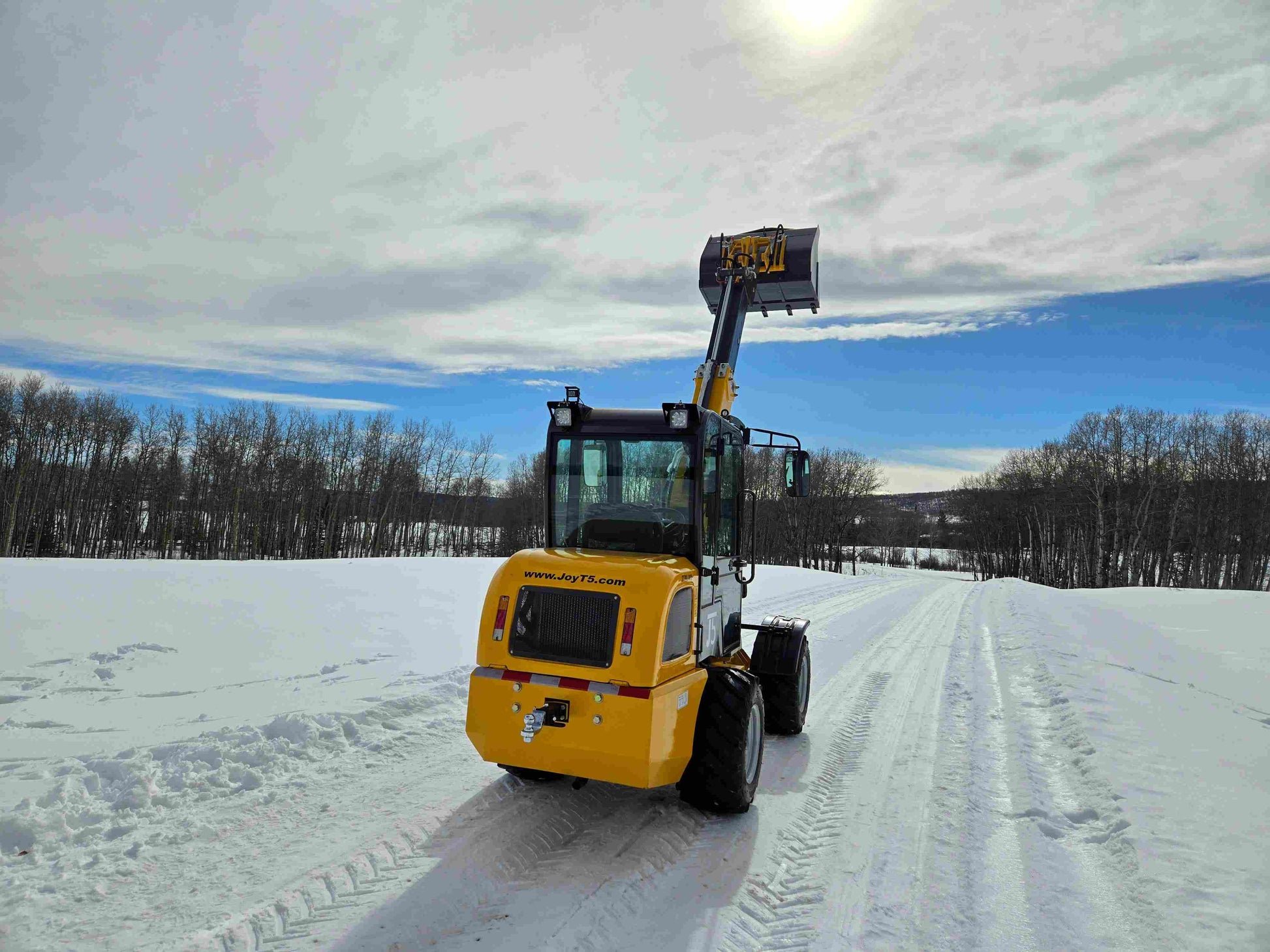 JT5WL1000 compact wheel loader 1 ton 2200 lbs rear view on snowy road with raised bucket