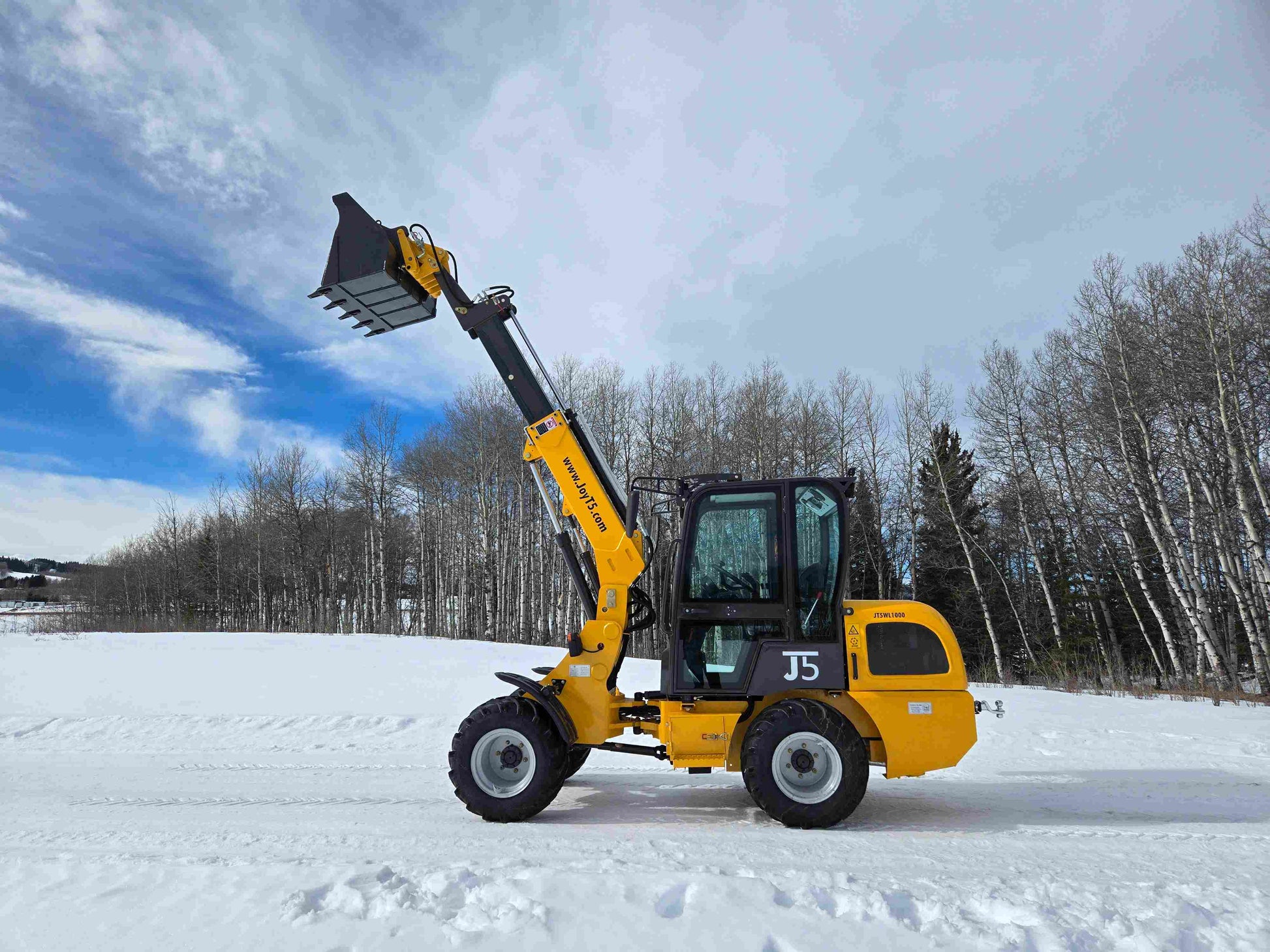 JT5WL1000 compact wheel loader 1 ton 2200 lbs side view with bucket lifted working in snow field
