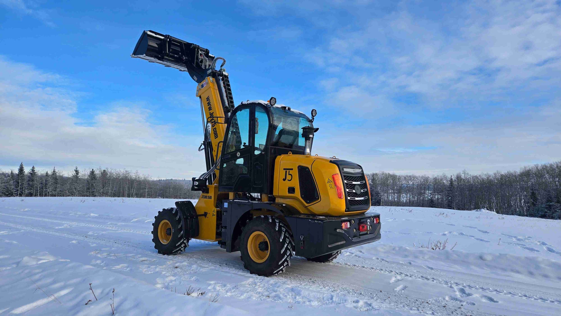 JT5WL1500 compact wheel loader rear side view with bucket raised on snowy field.