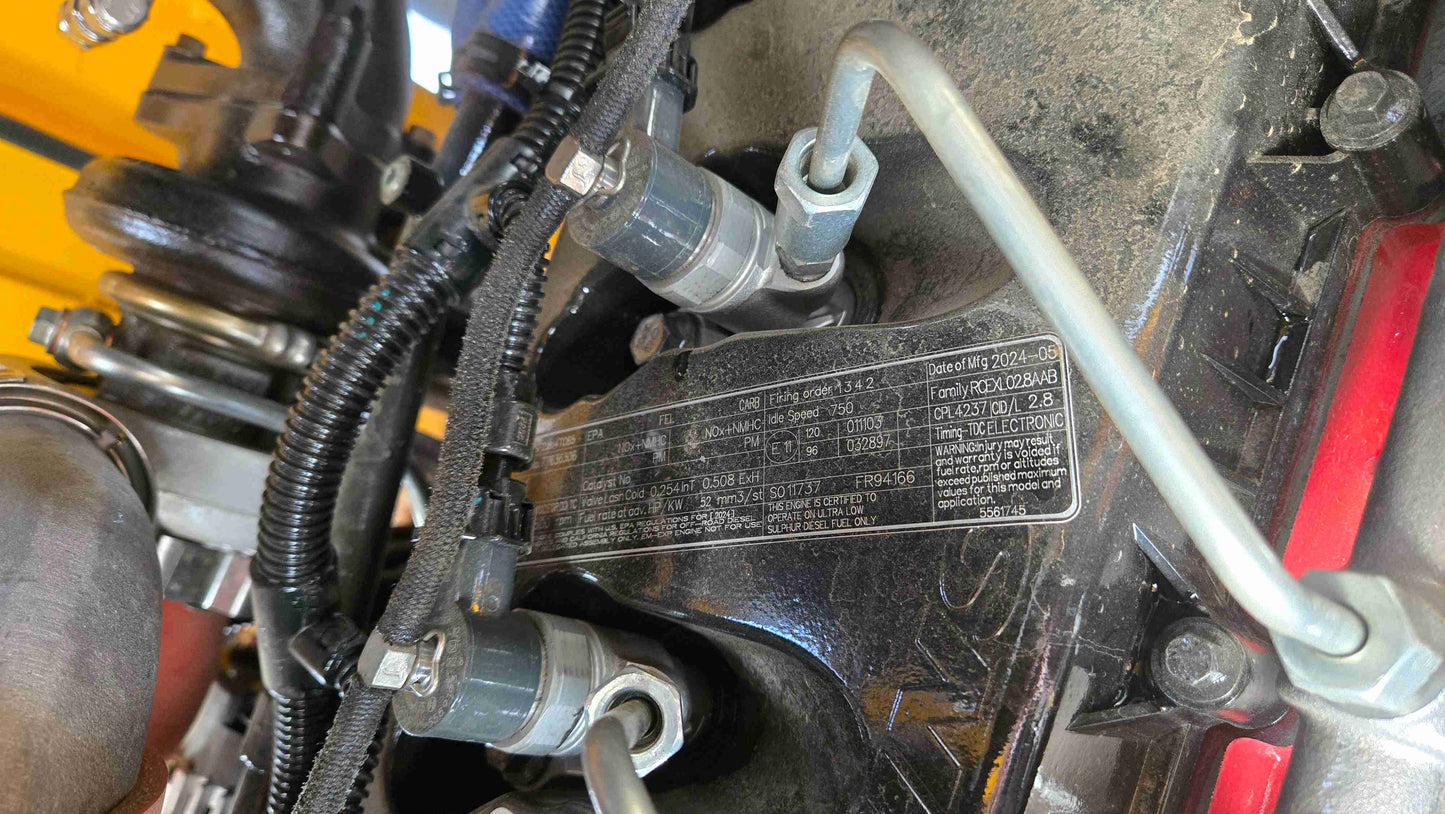 Engine identification plate showing model, family, CPL number, and emission data of JT5WL1500 wheel loader.