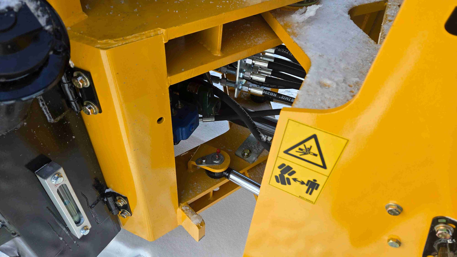 Close-up view of JT5WL1500 wheel loader hydraulic system and safety label.