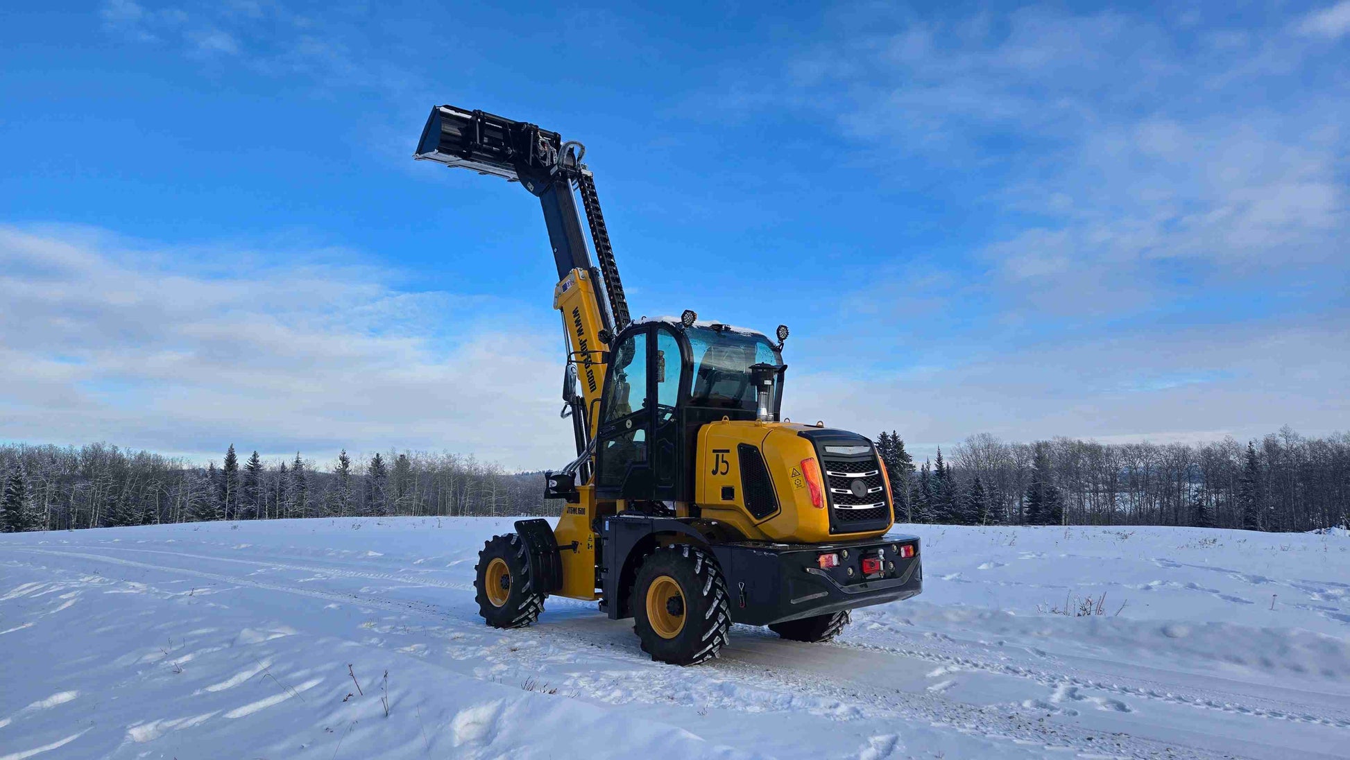 JT5WL1500 wheel loader rear side view with raised boom and bucket in a snowy outdoor field.