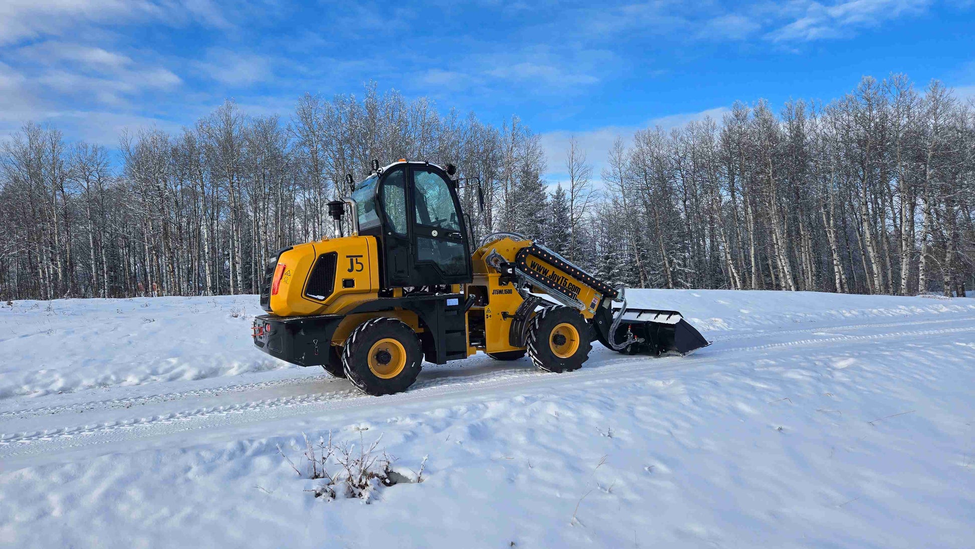 Full side view of JT5WL1500 wheel loader with bucket in snow-covered landscape.