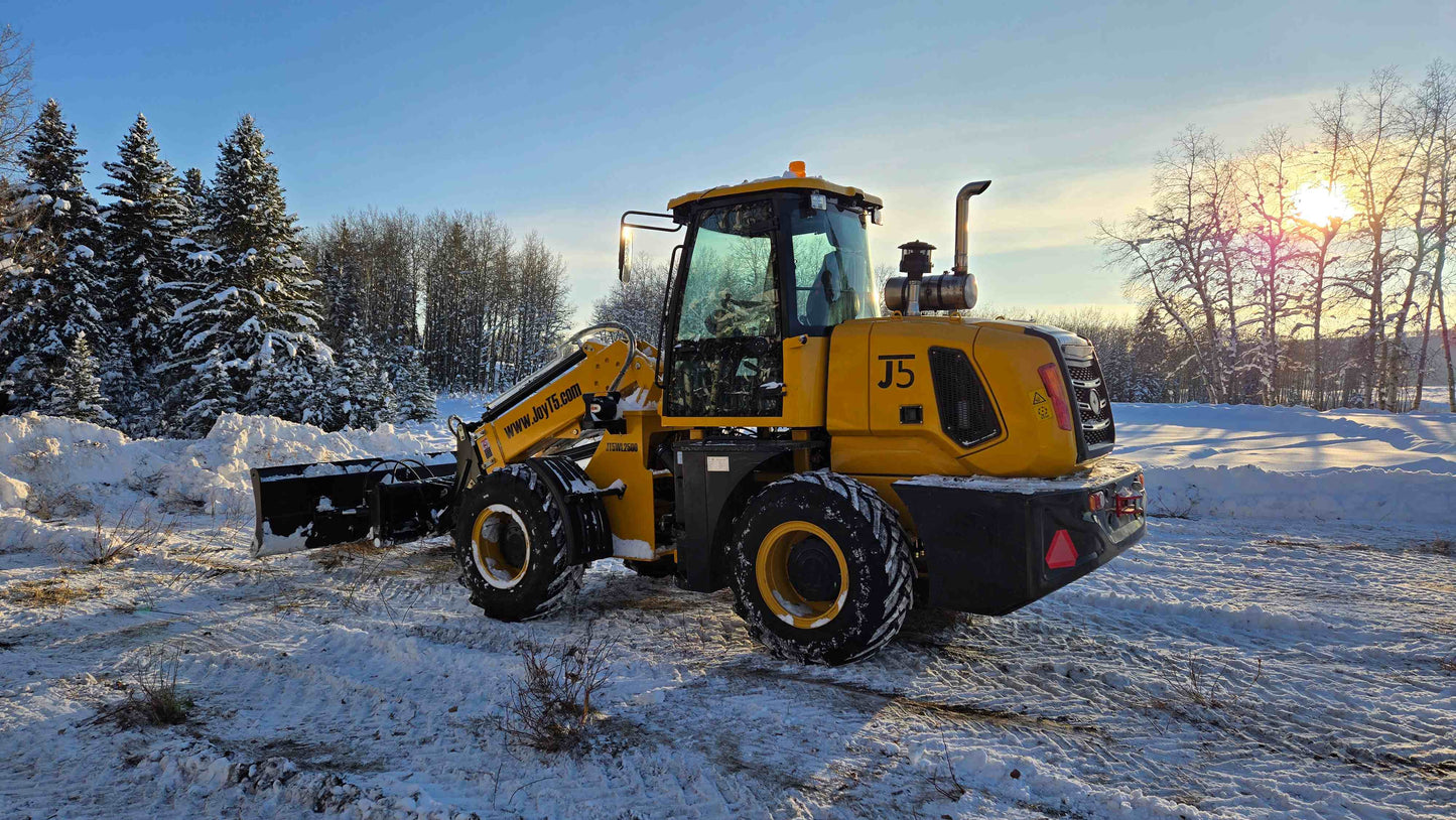 JT5WL2500 compact wheel loader clearing snow in Canada during winter sunset, efficient mini loader for construction and landscaping.
