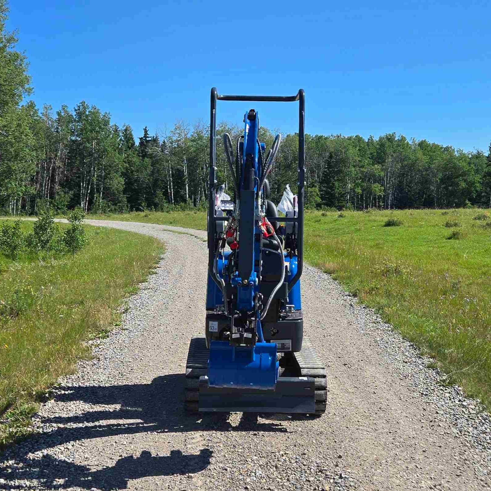 Rippa R13 mini excavator for sale by JoyT5 on a gravel path with green fields and trees in the background.