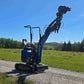 Rippa R13 mini excavator for sale by JoyT5 on a gravel road with a clear blue sky and green fields in the background