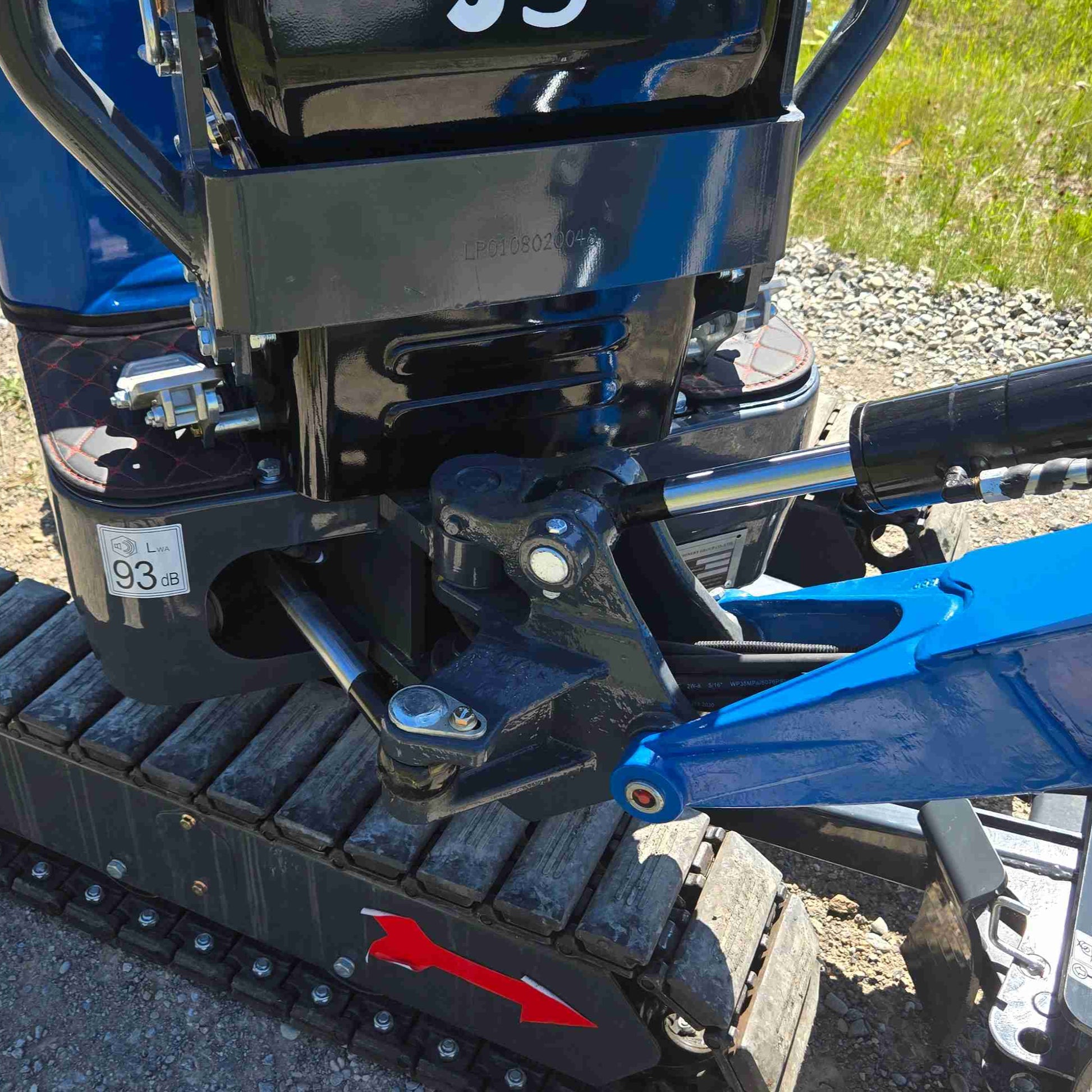 Side swing boom closeup of Rippa R13 mini excavator for sale by JoyT5 on a gravel surface with grass in the background