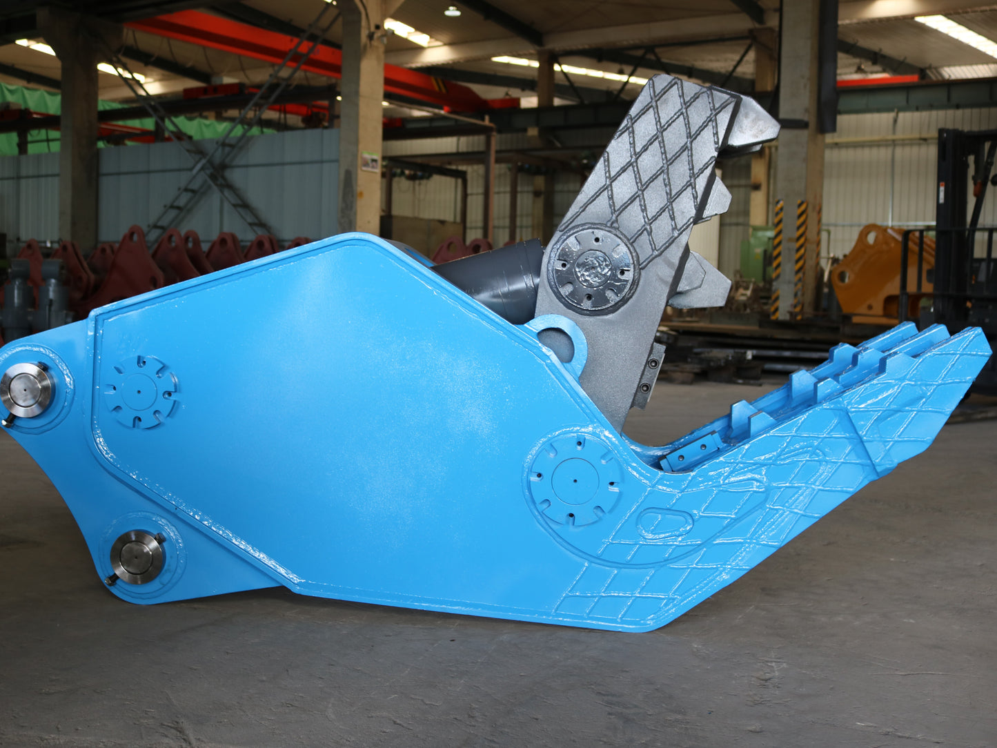 Blue hydraulic concrete pulverizer for excavator made in Canada designed for breaking stone and crushing reinforced concrete in demolition projects



