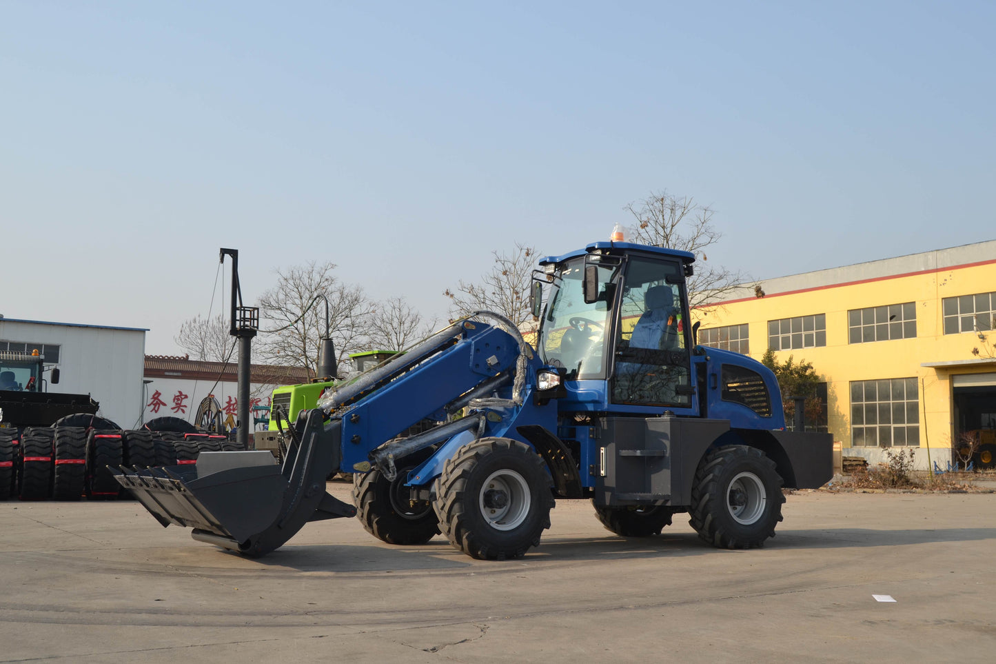Blue wheel loader with front bucket attachment for construction and material loading tasks
