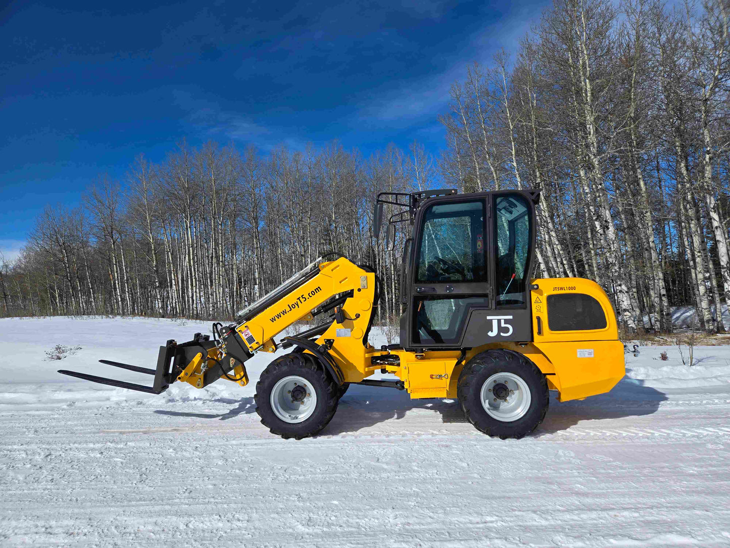 JT5WL1000 One ton compact wheel loader with pallet fork attachment working in snow for farm and construction use in Canada