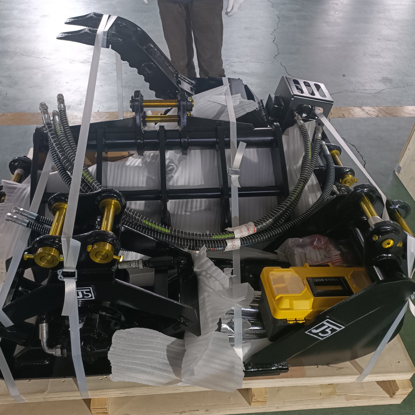 custom excavator attachments made in Canada including bucket hydraulic thumb and grapple packed for shipping heavy duty construction tools