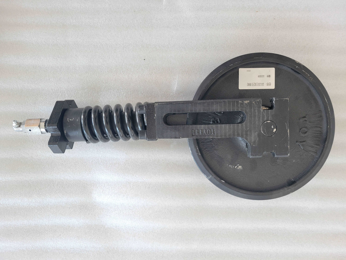 Excavator idler wheel and spring tension assembly for undercarriage replacement and heavy equipment maintenance in Canada
