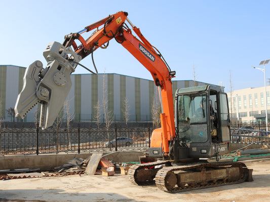 Excavator with rotating hydraulic shear attachment for demolition work.