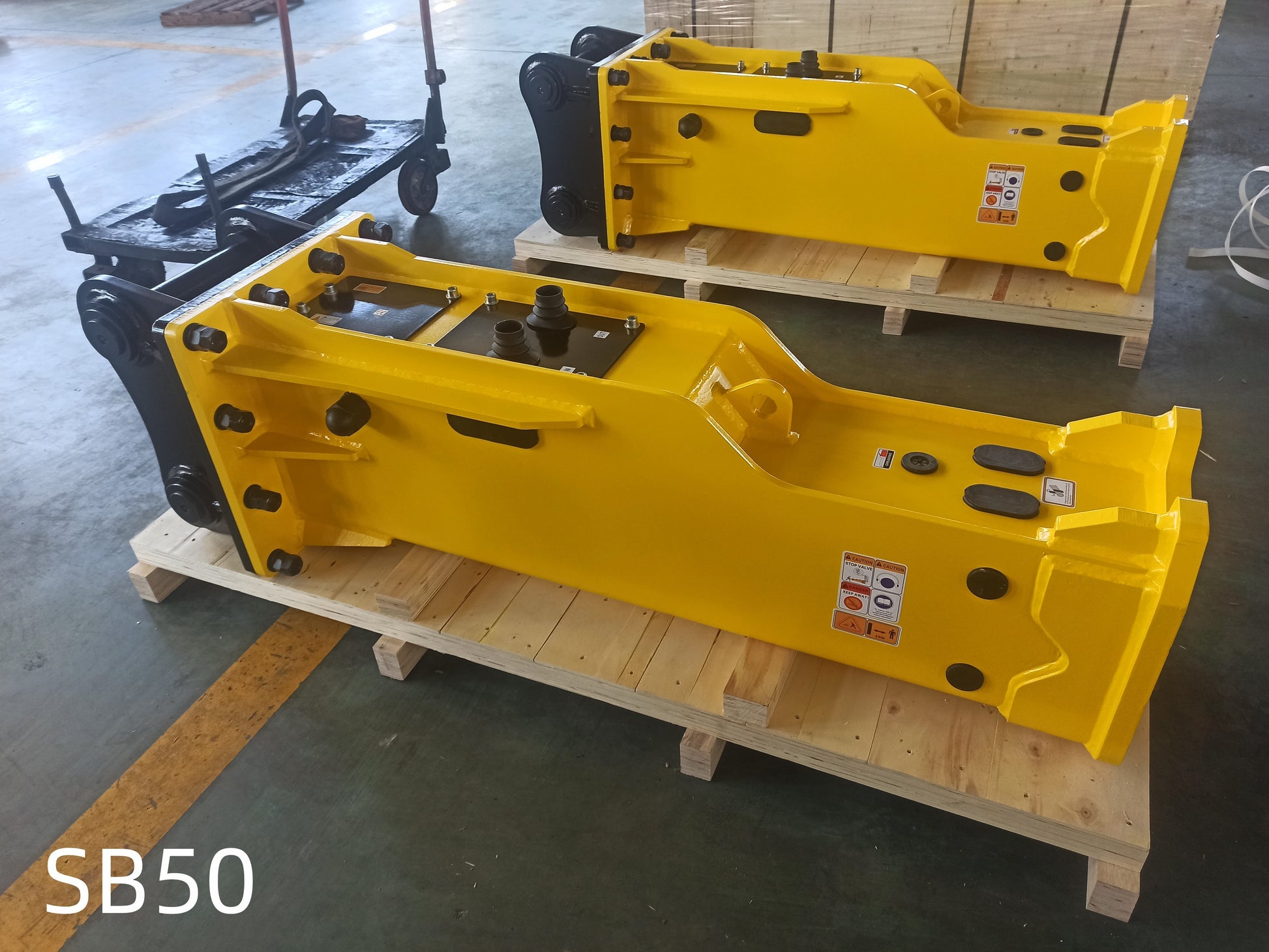 Hydraulic breaker hammer for excavators Canada and USA showing SB50 yellow heavy duty breaker attachments on pallets used for demolition and construction equipment.


