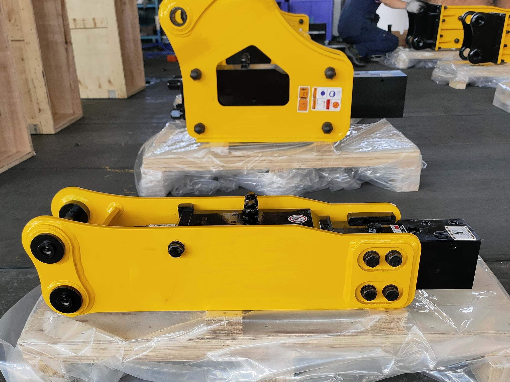 Hydraulic breaker hammer for excavators Canada and USA showing yellow heavy duty models in factory ready for shipment used for demolition and construction equipment.