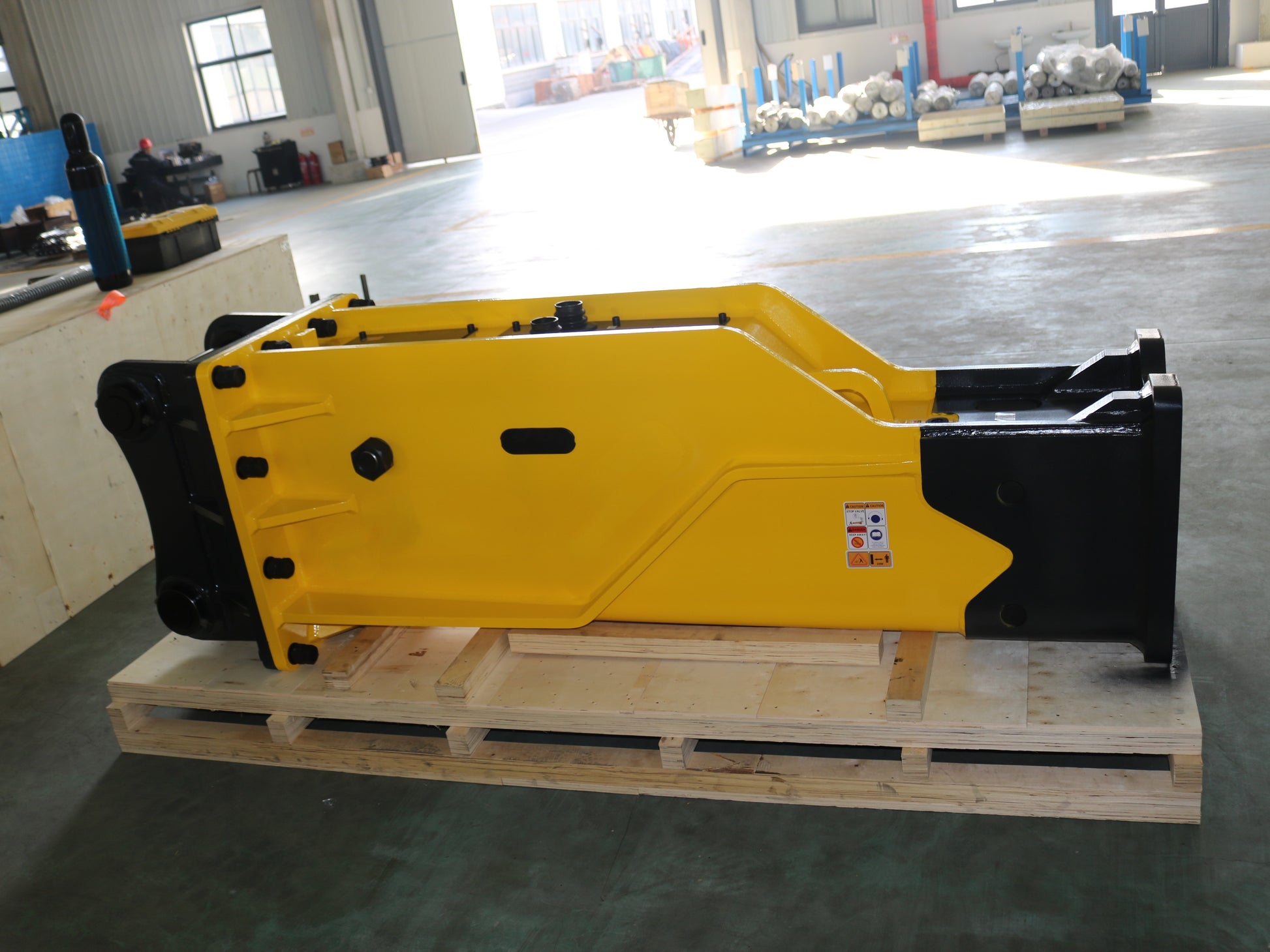 Hydraulic breaker hammer for excavators Canada and USA showing yellow heavy duty breaker tool on pallet ready for demolition and construction attachment work.