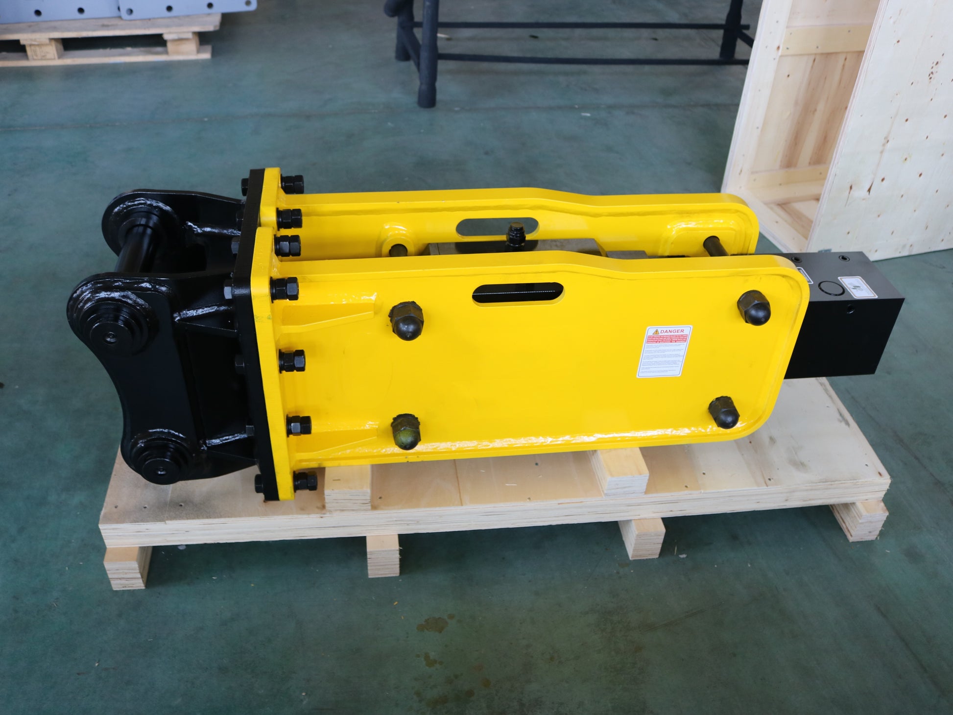 Hydraulic breaker hammer for excavators Canada and USA showing yellow heavy duty breaker tool on pallet ready for construction and demolition equipment use.