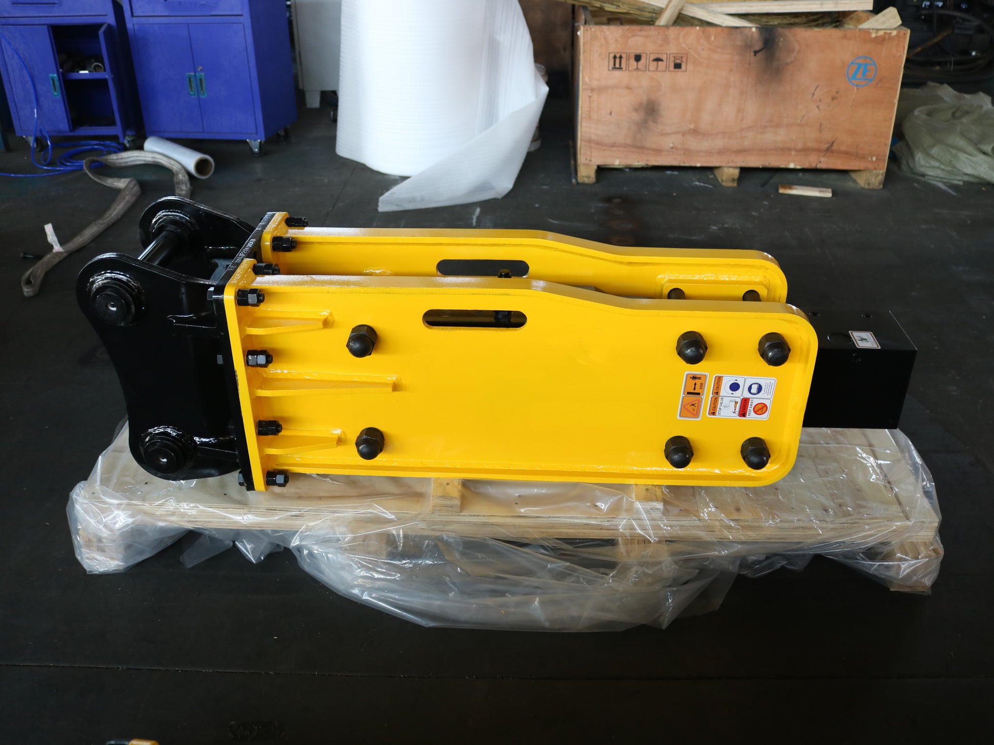 Hydraulic breaker hammer for excavators Canada and USA showing yellow heavy duty breaker attachment on pallet wrapped for delivery and construction equipment use.

