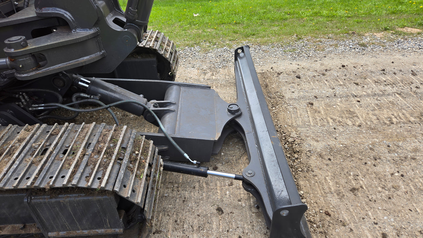 Close up view of hydraulic dozer blade and track system on a JoyT5 mini excavator in Canada used for grading construction sites
