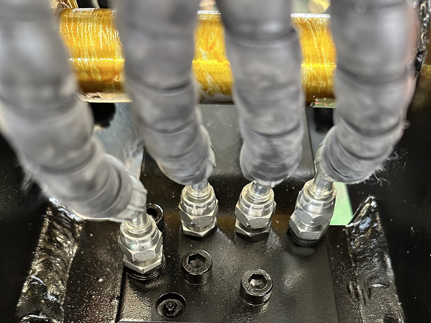 Close up of hydraulic hose connection for excavator quick hitch coupler made in Canada showing high pressure fittings for efficient construction equipment operation



