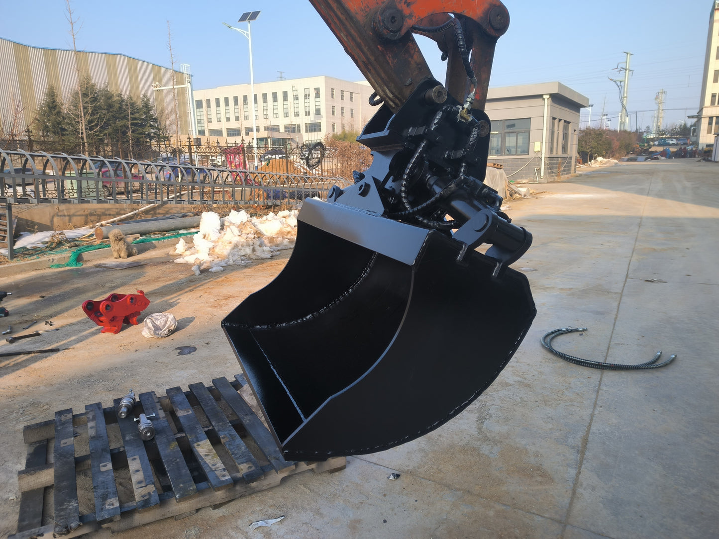 Hydraulic tilt bucket attachment mounted on excavator at construction site in Canada showing durable design for grading digging and earthmoving tasks