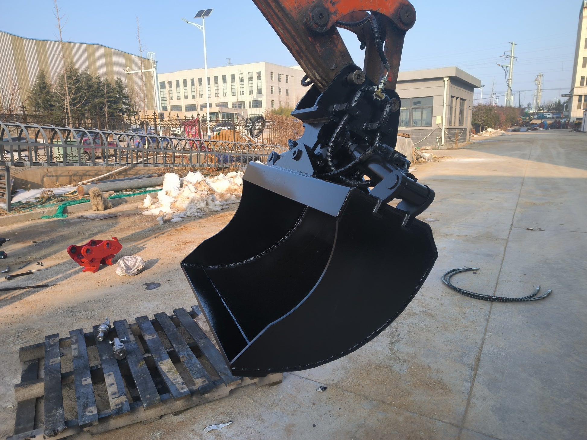 Hydraulic tilt bucket attachment mounted on excavator at construction site in Canada showing durable design for grading digging and earthmoving tasks