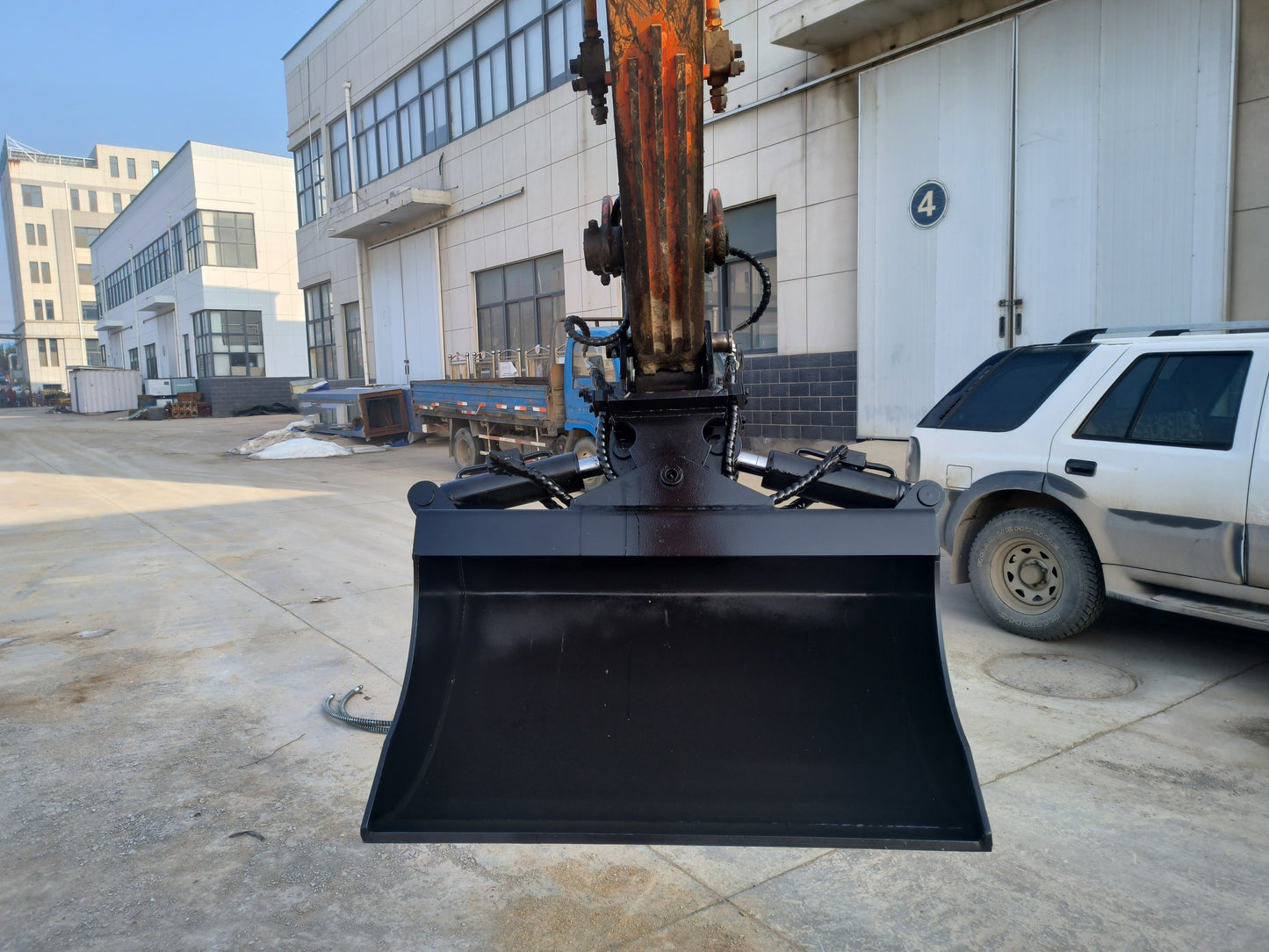Hydraulic tilt bucket attached to excavator front view working on construction site in Canada ideal for digging grading and heavy duty earthmoving tasks


