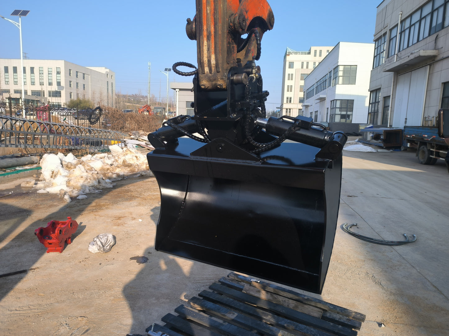 Hydraulic tilt bucket attached to excavator working on site in Canada showing heavy duty design for digging grading and leveling construction ground


