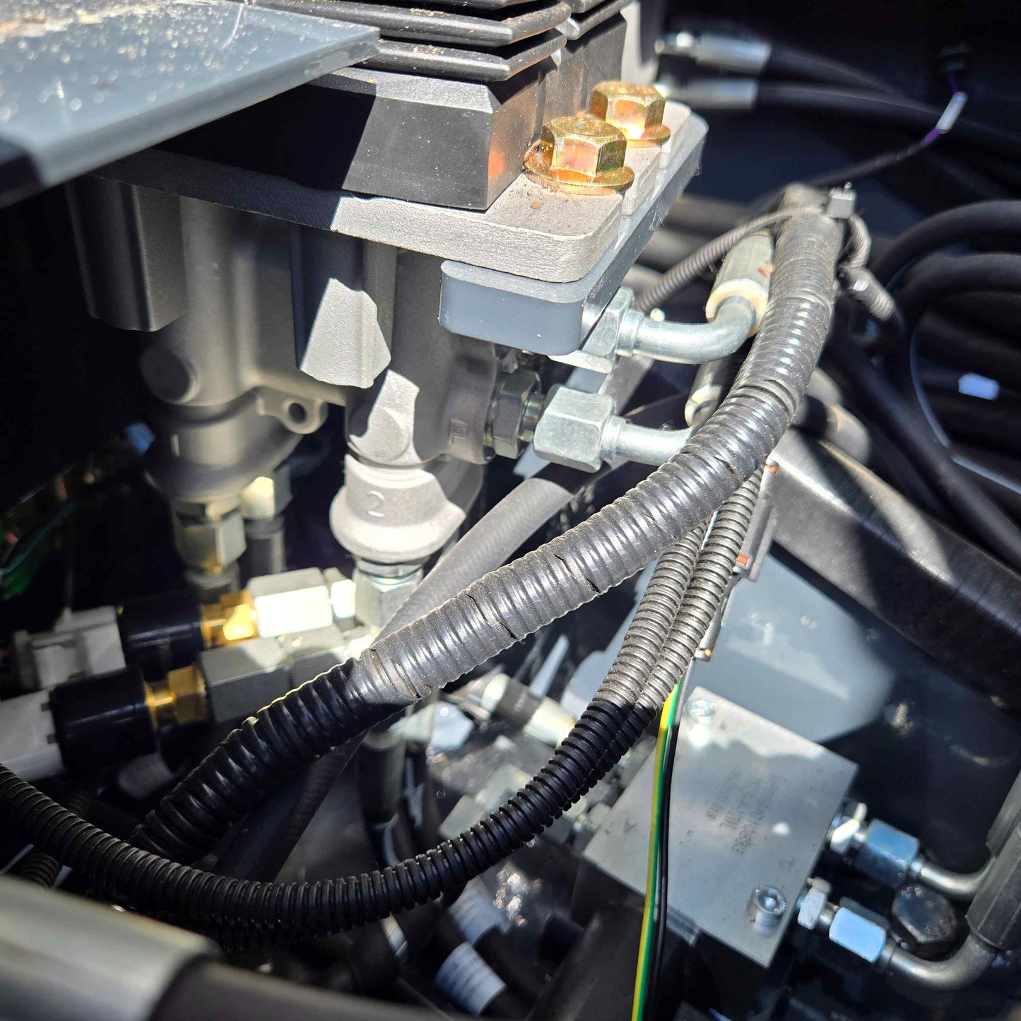 Detailed view of the hydraulic control valve and hoses inside a JoyT5 mini excavator in Canada