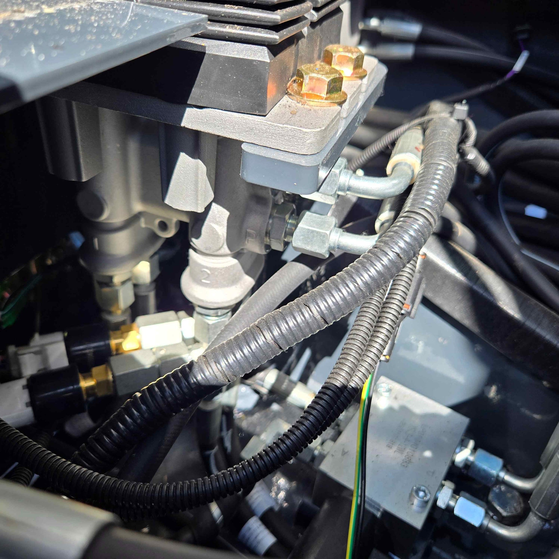 Detailed view of the hydraulic control valve and hoses inside a JoyT5 mini excavator in Canada