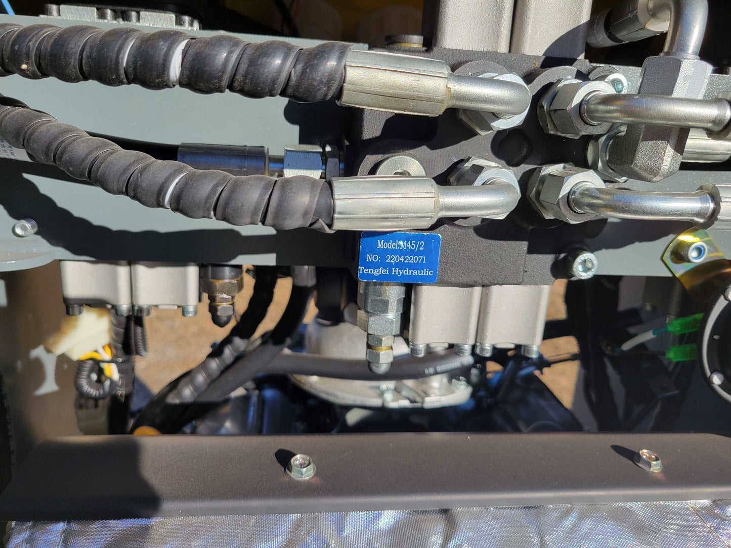 Close-up of JoyT5 JT5SSTM3 mini skid steer loader hydraulic system with Tengfei hydraulic valve and connected hoses