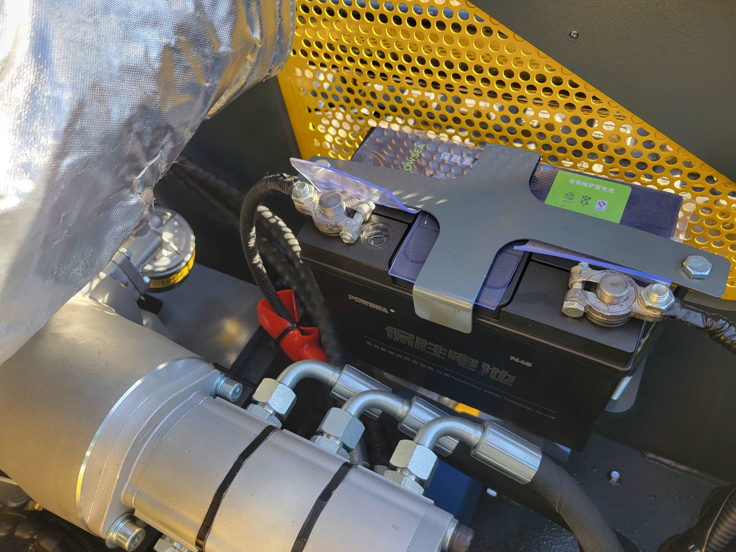 Close-up view of the battery and hydraulic connections inside JoyT5 JT5SSTM3 mini skid steer loader